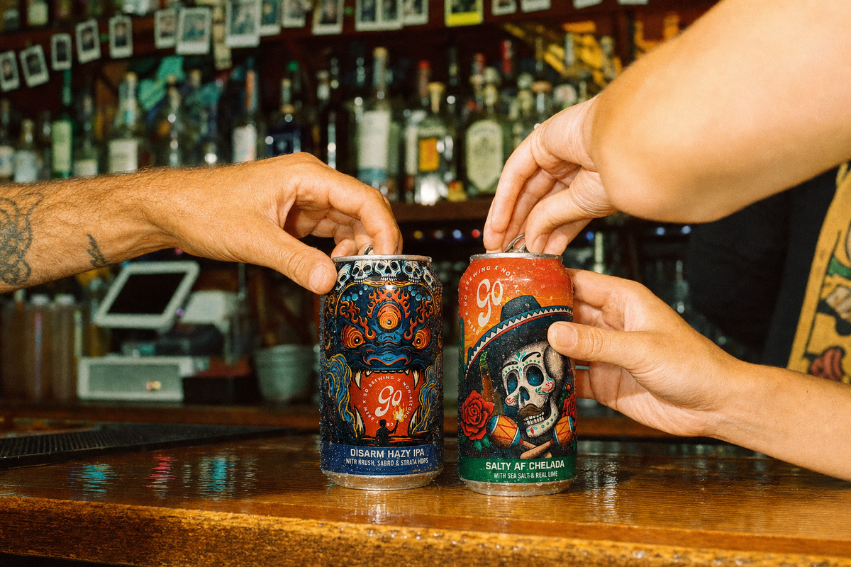 Two people opening cans of Go Brewing Disarm Hazy IPA and Salty AF Chelada on a bar