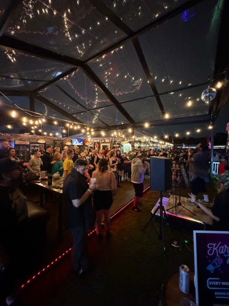 Non-alcoholic dive bar with lively crowd enjoying music and atmosphere under string lights.