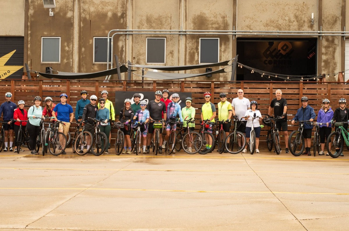 Riders gathered with their bikes outside the Go Brewing / Blind Corner Taproom before the Forever Bloom charity ride